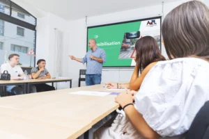 Instructeur donnant un cours de sensibilisation à l'auto-école AEL, étudiants à l'écoute